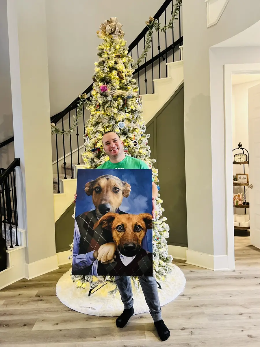 Pet parent holding a personalized portrait of two dogs